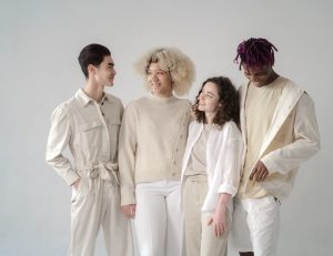 A diverse group of friends dressed stylishly, smiling in a studio setting.